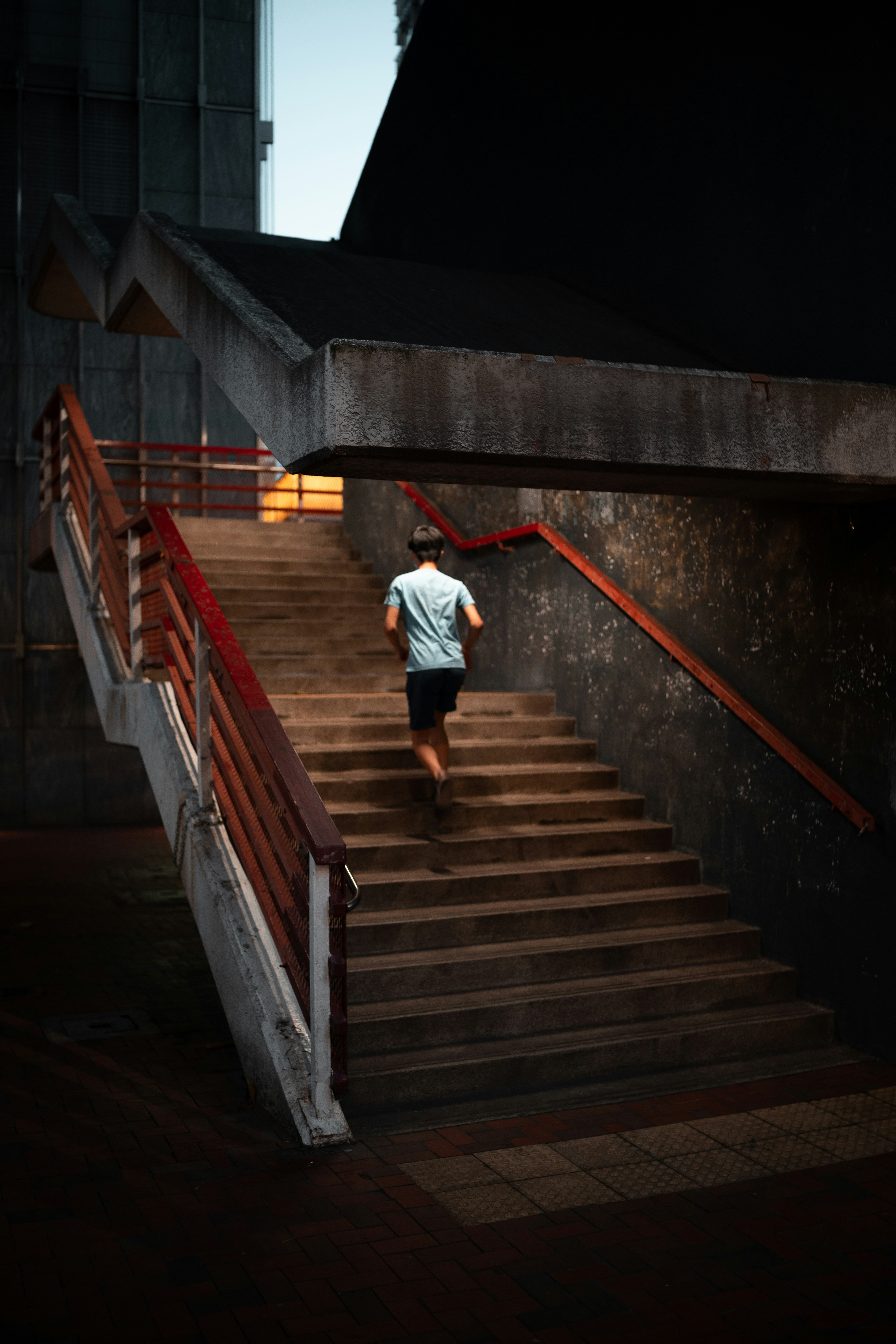 man in white shirt and red pants walking on brown staircase
